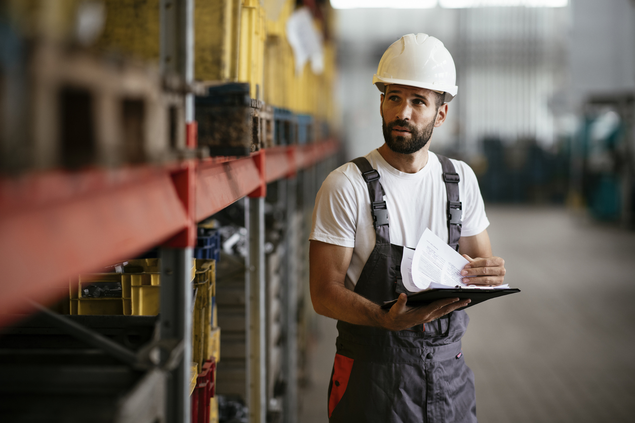 Factory worker working in industrial building indoor. 