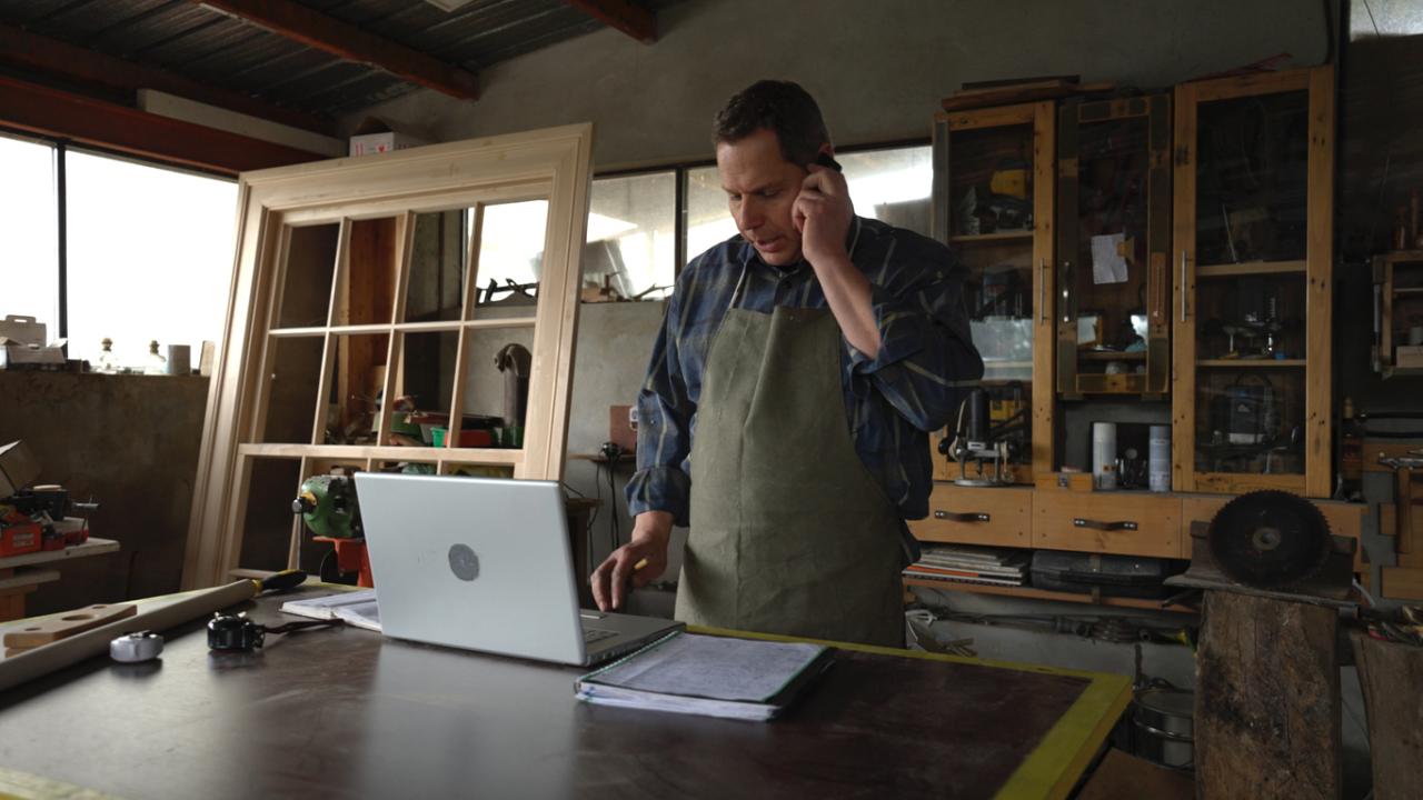 Carpenter taking phone order in his workshop
