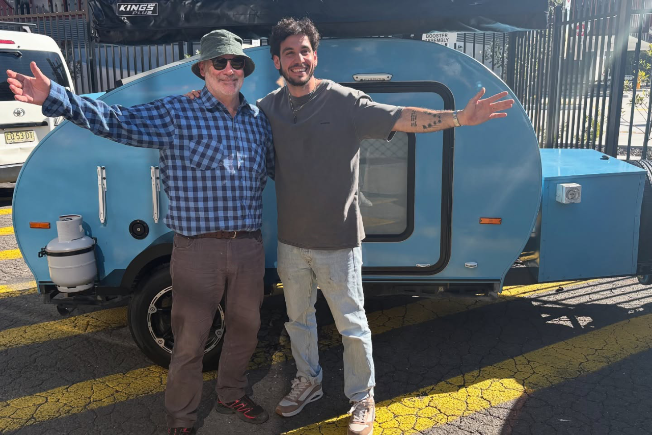 two men standing in front of a trailer
