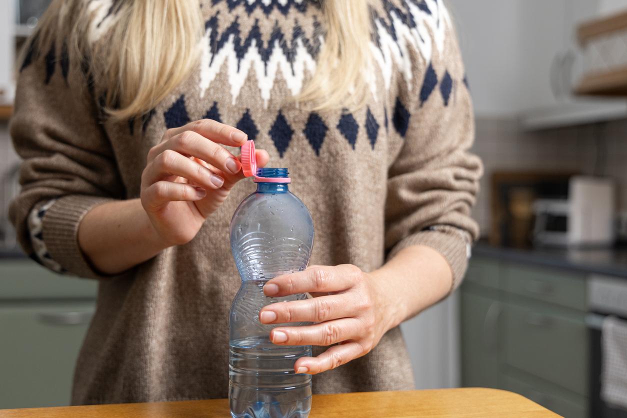 Woman holding plastic bottle with colorful cap
